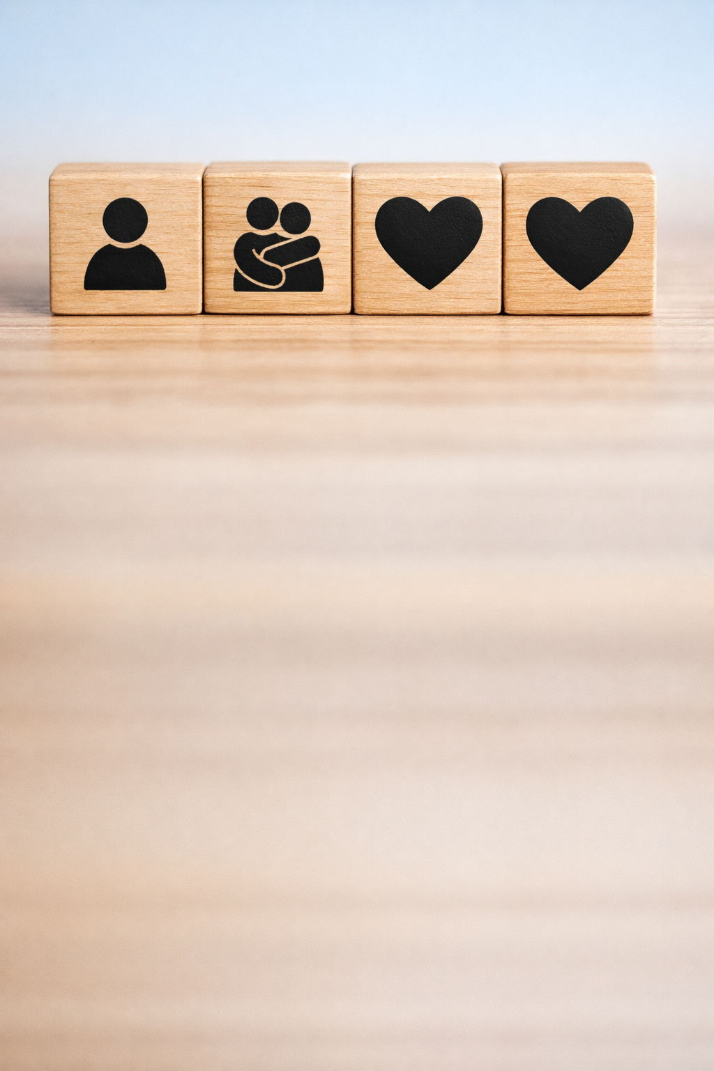 The image shows a closeup of a hand arranging wooden blocks with icons representing different person icons  2 persons hugging The hand is in the proce-4